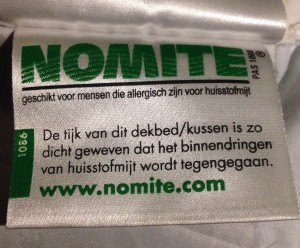 Het Nomite label op een donzen kussen